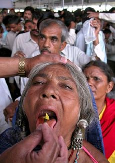 Obrovské množství Indů vyhledává pomoc léčitelů. Na snímku žena trpící astmatem polyká živou sardinku z rukou léčitele.