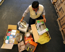 Pracovník Syrského arabského červeného kříže (SARC) rozděluje balíčky pomoci. 