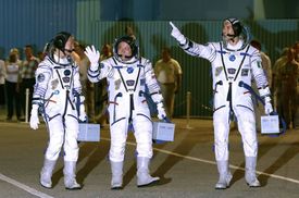 Americká astronautka Karen Nybergová, Rus Fjodor Juršichin (uprostřed) a italský astronaut Luka Parmitano se chystají k odletu do vesmíru.