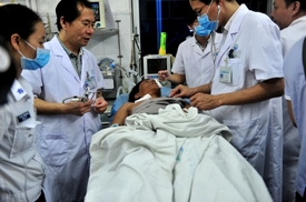 Čínští lékaři se snaží zachránit rybáře z potopené lodi.