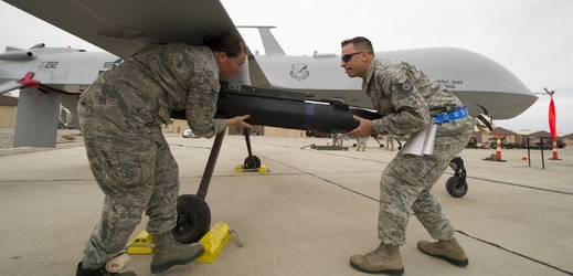 Američtí vojáci vyzbrojují dron raketou.