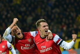 Mesut Özil (vlevo) s Aaronem Ramseyem oslavují vítězství Arsenalu v Dortmundu.
