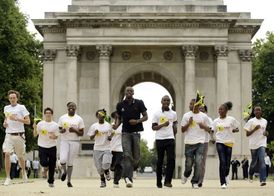 Jamajské děti mají symetričtější kolena než ty britské. Na snímku Usain Bolt s mládeží při londýnském běhu.