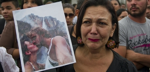 Protest proti násilí. Venezuelská demonstrantka s fotografií zavražděného páru, bývalé miss a jejího exmanžela.