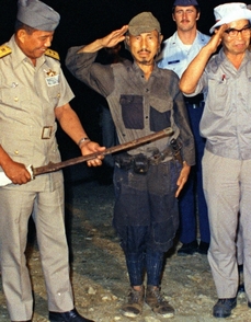 Onoda po kapitulaci v roce 1974 odevzdává svůj meč.