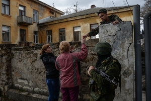 Ženy krmí přes zeď ukrajinské vojáky na jejich obležené základně v Simferopolu.