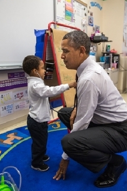Při návštěvě zákl. školy měří žáček Obamovi tlukot srdce.