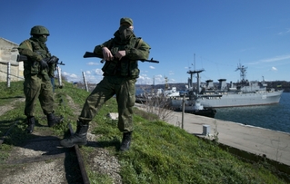 Neidentifikovaní proruští ozbrojenci střeží ukrajinské lodě na Krymu.