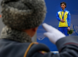 Ukrajinská paralympijská sportovkyně Olexandra Kononová si zakrývá rukou zlatou medaili během slavnostního předávání.