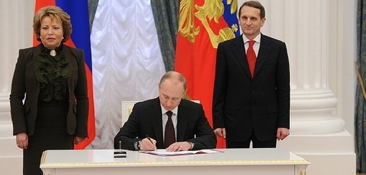 Putin podepisuje zákony o připojení Krymu k Ruské federaci.