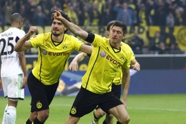 Robert Lewandowski slaví gól se spoluhráči z Dortmundu.