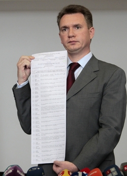 Šéf ukrajinské volební komise ukazuje hlasovací arch.