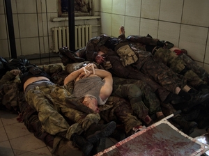 Mrtví separatisté naskládaní na hromadu v doněcké márnici.