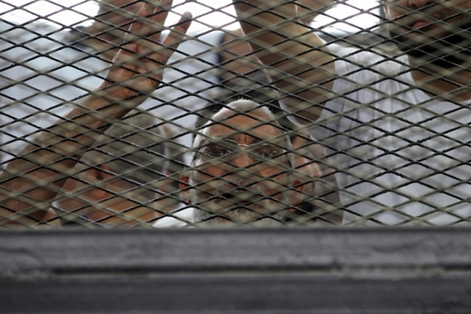 Členové Muslimského bratrstva během jejich soudu stojí uvnitř železné klece.