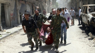 Rebelové nesou zraněného v Aleppu.