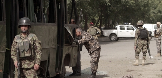 Příslušníci afghánské bezpečnosti prohledávají zničený vojenský autobus po sebevražedném atentátu v Kábulu.