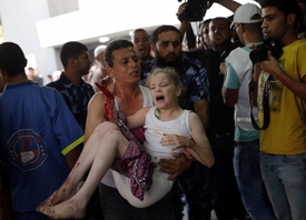 Palestinec nese zraněnou dívku na pohotovost v Gaze.