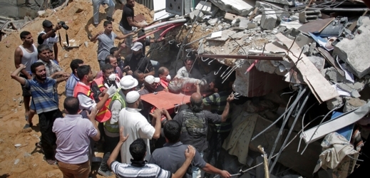 Palestinští záchranáři hledají v troskách domu mrtvá těla.