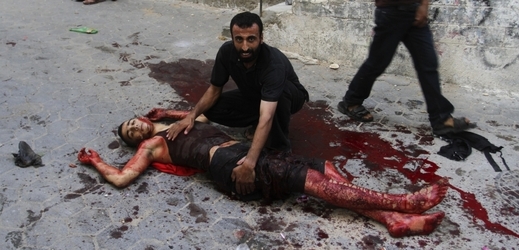 Zraněný čeká na pomoc po izraelském bombardování.