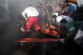 Palestinští zdravotníci odnášejí těla lidí zabitých při izraelském náletu.