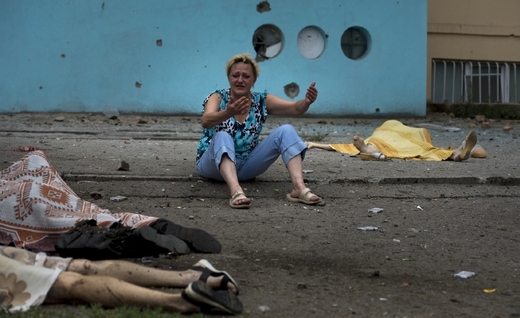 Válečné zločiny? Zoufalá žena nad mrtvými, z nichž jsou někteří její blízcí, po ostřelování Lunansku ukrajinskou armádou.