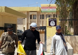 Islamisté nahrazují kurdské vlajky ve městě Bartella svými.