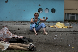 Zoufalá žena v Luhansku. Kolem ní mrtví blízcí, které zabily ukrajinské granáty.