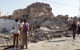 Lidé si prohlížejíí zničenou mešitu v centru Mosulu, 28. červenec 2014.