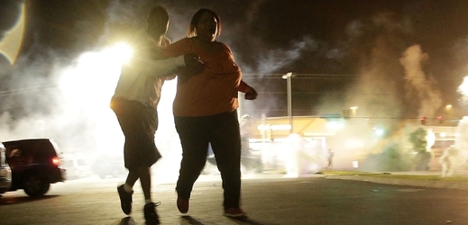 Demonstrantky ve Fergusonu utíkají před slzným plynem.