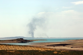 Nad krajinou obklopující vodní dílo se po americkém bombardování vznáší dým.