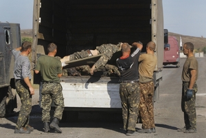 Ukrajinští vojáci nakládají své mrtvé spolubojovníky u obce Starobeševo.