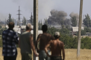 Obyvatelé Novoazovsku sledují výbuchy granátů. 