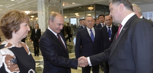 Putin (vlevo) si podává ruku s Porošenkem při jednání v Minsku.