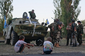 Děti pozorují ukrajinské vojáky u Luhansku.