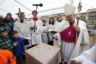 Biskup poklepává na základní kámen kostela v Lipsku.