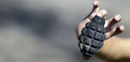 Chlapec drží v ruce nevybuchlý granát v obci Novosvitlikov. 