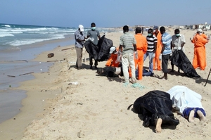 Utopení běženci vyplavení na pláž u libyjského Tripolisu.