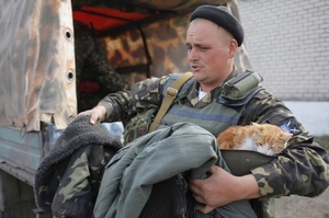 Ukrajinský voják u Luhansku si přináší teplé oblečení a kočku.