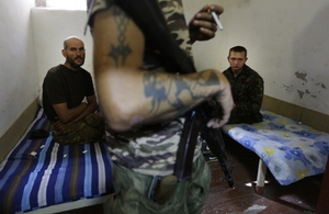 Separatista hlídá ukrajinské zajatce.