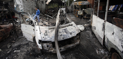 Zničená budova a vozidla v ostřelovaném ukrajinském Doněcku.