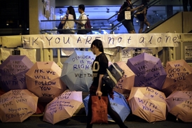 Protestující studentka prochází kolem deštníků se vzkazy podpory Hongkongu z celého světa.