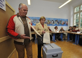 Voliči vhazují své hlasy do urny.