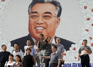 Turisté se fotí u portétu Kim Ir-sena.