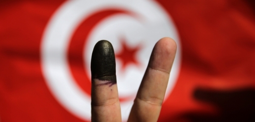 Muž po hlasování ve volbách ukazuje inkoustem označený prst.