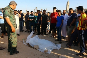Utopení uprchlíci na pláži u libyjského Tripolisu.