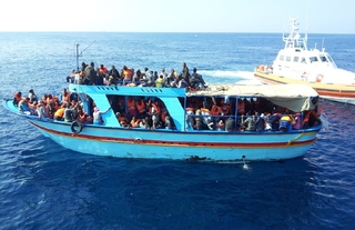 Přeplněná loď s běženci z Afriky u Lampedusy.