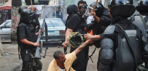 Policisté zadržují stoupence svrženého prezidenta Mursího při demonstraci 14. srpna 2014.