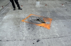 Dělostřelecký granát zaklíněný na střeše poškozené budovy muničního skladu.