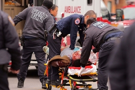 Postřelený Ismaaiyl Brinsley odvážen ambulancí.