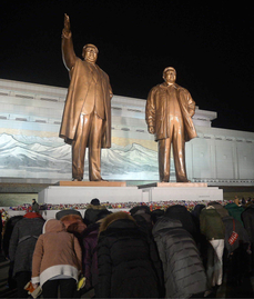 Obyvatelé Pchjongjangu se klaní sochám vůdců na oslavy Nového roku.